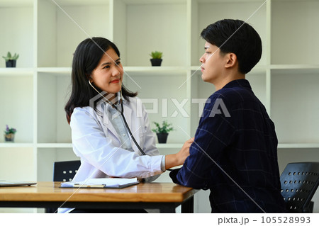 Female doctor using stethoscope, listening to male patient breath or heartbeat. Healthy care, medicine and insurance concept 105528993