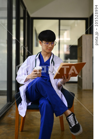 Portrait of medical student man wearing headphone and reading book. Medical internship concept Portrait of medical student man wearing headphone and reading book. Medical internship concept 105528994