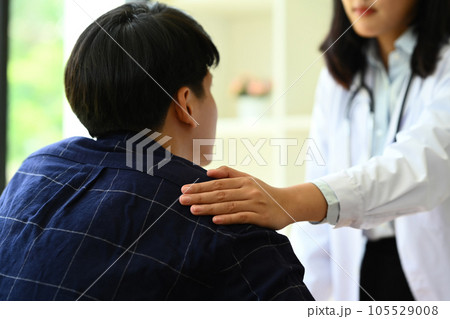 Psychologist comforting and supporting man patient at medical appointment. Psychotherapy and mental health concept 105529008