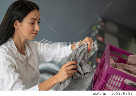 Young brunette woman doing laundry. Young brunette woman doing laundry. 105530255