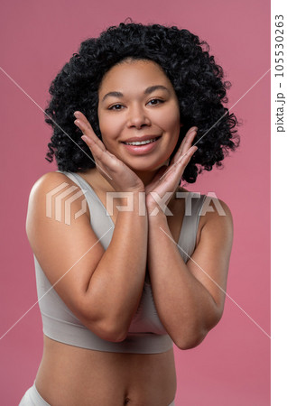 Curly-haired young woman in lingerie on pink background 105530263
