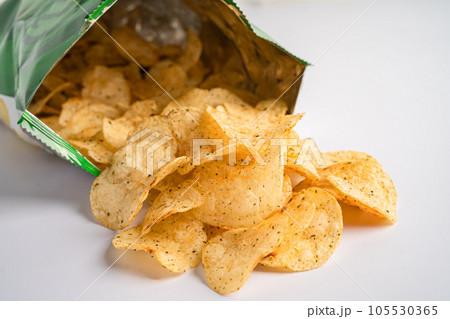 Potato chips, delicious spicy for crips, thin slice deep fried snack fast food in open bag. 105530365