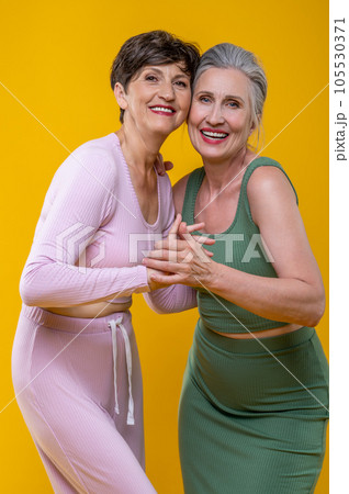 Active senior women standing close and smiling happily 105530371