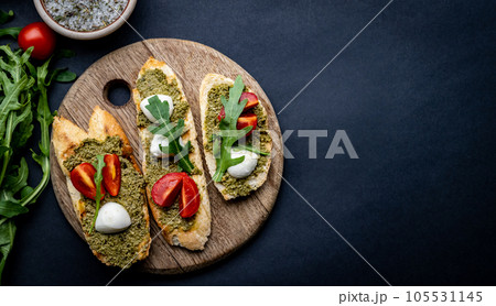 Bruschettas with pesto and tomatoes Bruschettas with pesto and tomatoes 105531145