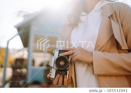 Young girl with retro camera enjoying autumn weather. 105532841