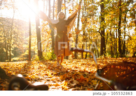 ?appy young woman having fun with leaves in autumn park. 105532863