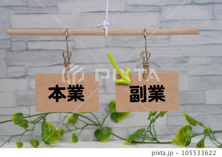 天秤に吊った本業と副業と矢印 105533622