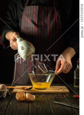 The chef uses a hand-held electric mixer to prepare a delicious egg breakfast or lunch. Menu idea for restaurant or hotel The chef uses a hand-held electric mixer to prepare a delicious egg breakfast or lunch. Menu idea for restaurant or hotel 105533958