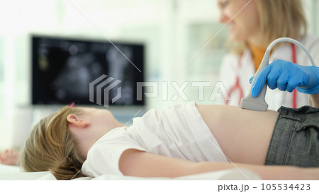 Doctor conducts ultrasound examination of internal organs of child in clinic Doctor conducts ultrasound examination of internal organs of child in clinic 105534423