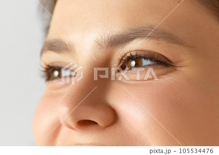 Close-up image of female face, eyes, nose. Woman with well-kept, smooth, glowing skin 105534476