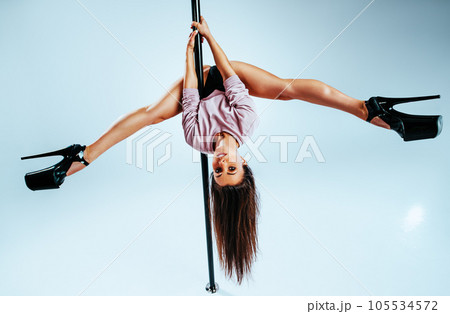 Young woman pole dancing Young woman pole dancing 105534572