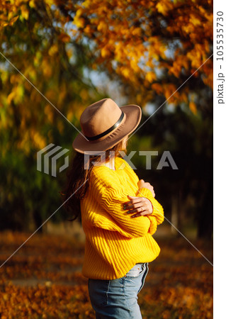 Young woman in a yellow sweater and jeans resting in nature. Fashion, style concept. People, lifestyle. 105535730