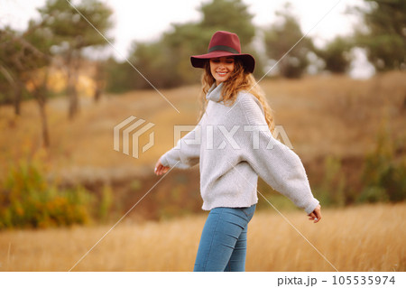 Stylish woman in hat enjoying autumn weather in the park. Fashion, style concept. Stylish woman in hat enjoying autumn weather in the park. Fashion, style concept. 105535974