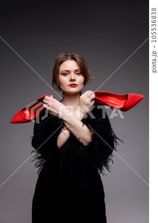 Woman holding red shoes Woman holding red shoes 105536838