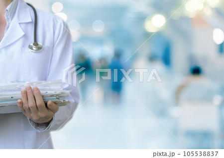 The doctor holds case histories in a stack of documents . 105538837