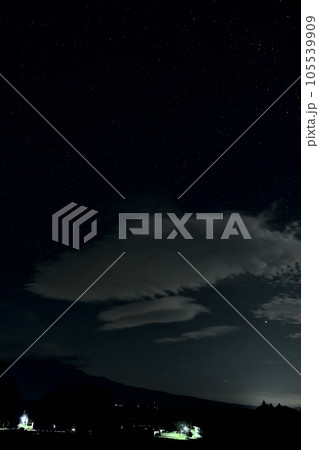 北杜市白州町、八ヶ岳の上の大きな雲の上と星空 105539909