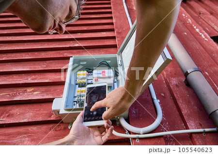 Taking readings from an electric meter located outdoors, using photography with camera on your phone. Taking readings from an electric meter located outdoors, using photography with camera on your phone. 105540623