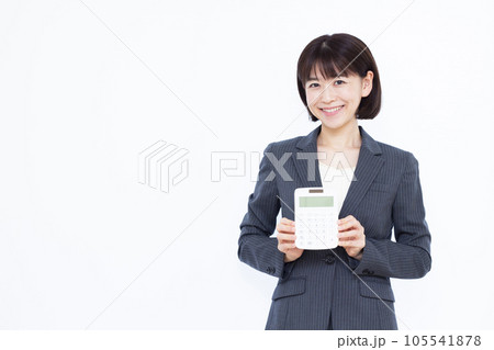 白い背景の前で電卓を持つ30代の働く女性 白い背景の前で電卓を持つ30代の働く女性 105541878