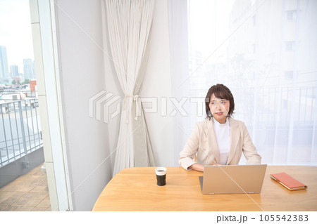 屋内の机でノートパソコンの操作をする若い女性 屋内の机でノートパソコンの操作をする若い女性 105542383