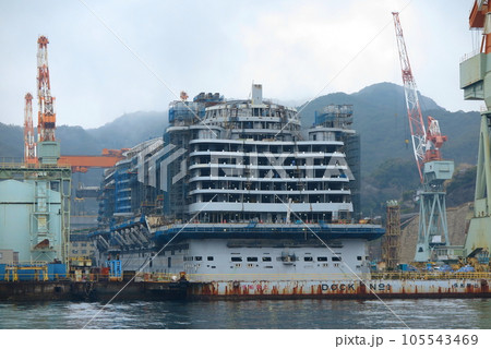 海上から眺めた、三菱重工長崎造船所のドックと、建造中のクルーズ客船 105543469
