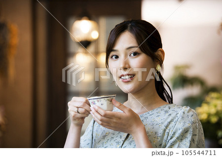カフェでコーヒーを飲む若い女性 カメラ目線 カフェでコーヒーを飲む若い女性 カメラ目線 105544711