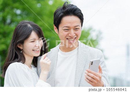 屋外でスマホを見るカップル・夫婦 屋外でスマホを見るカップル・夫婦 105546041