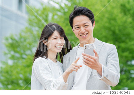 屋外でスマホを見るカップル・夫婦 屋外でスマホを見るカップル・夫婦 105546045