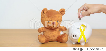International Childhood Cancer Awareness month, Children toy with golden yellow color Ribbon with Piggy Bank for Donation, Charity, Campaign, Money Saving, Fund and World cancer day concept International Childhood Cancer Awareness month, Children toy with golden yellow color Ribbon with Piggy Bank for Donation, Charity, Campaign, Money Saving, Fund and World cancer day concept 105548123