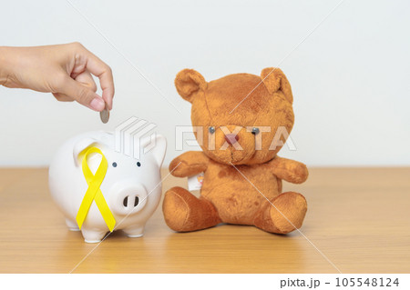 International Childhood Cancer Awareness month, Children toy with golden yellow color Ribbon with Piggy Bank for Donation, Charity, Campaign, Money Saving, Fund and World cancer day concept International Childhood Cancer Awareness month, Children toy with golden yellow color Ribbon with Piggy Bank for Donation, Charity, Campaign, Money Saving, Fund and World cancer day concept 105548124