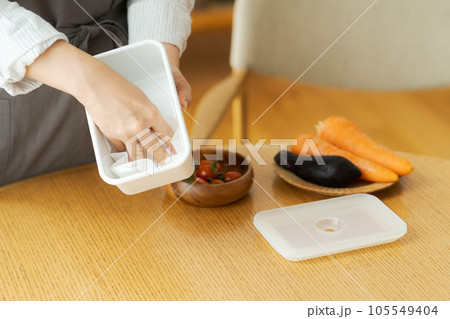 保存容器を拭く女性の手元写真 105549404