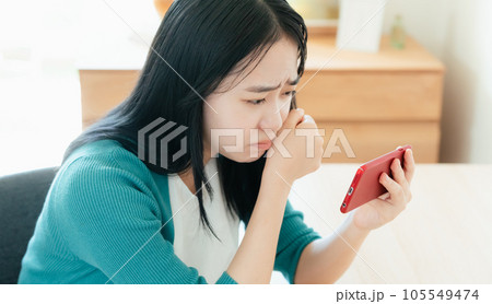 スマートフォンで動画視聴する若い女性 スマートフォンで動画視聴する若い女性 105549474