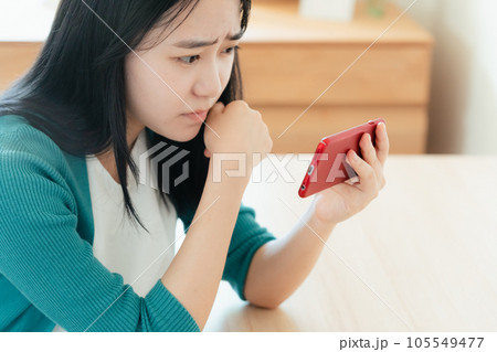 スマートフォンで動画視聴する若い女性 スマートフォンで動画視聴する若い女性 105549477