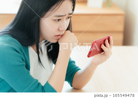 スマートフォンで動画視聴する若い女性 スマートフォンで動画視聴する若い女性 105549478