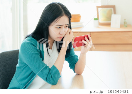 スマートフォンで動画視聴する若い女性 スマートフォンで動画視聴する若い女性 105549481