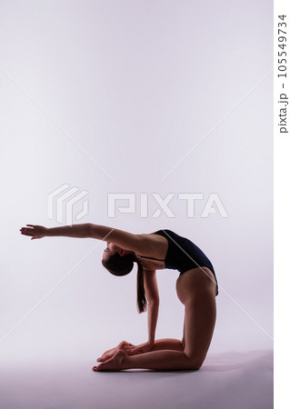 Athletic woman in swimsuit doing yoga, plank pose variation, beautiful female exercising studio 105549734
