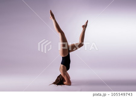 Athletic woman in swimsuit doing yoga, plank pose variation, beautiful female exercising studio Athletic woman in swimsuit doing yoga, plank pose variation, beautiful female exercising studio 105549743