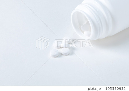 白いボトルの口からこぼれる錠剤　アップ 105550932