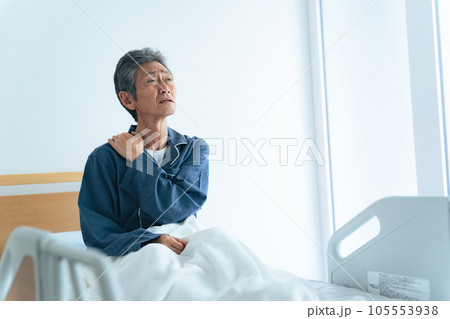 ベッドで起き上がって疲れに悩むシニア男性 105553938
