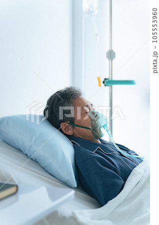 酸素マスクをつけてベッドに寝るシニア男性 酸素マスクをつけてベッドに寝るシニア男性 105553960