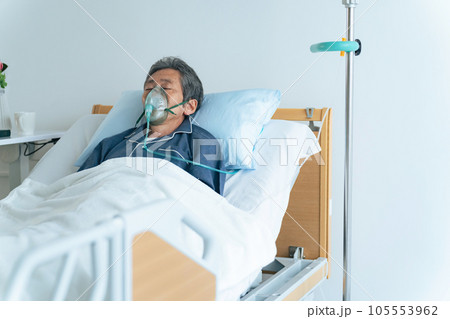 酸素マスクをつけてベッドに寝るシニア男性 酸素マスクをつけてベッドに寝るシニア男性 105553962