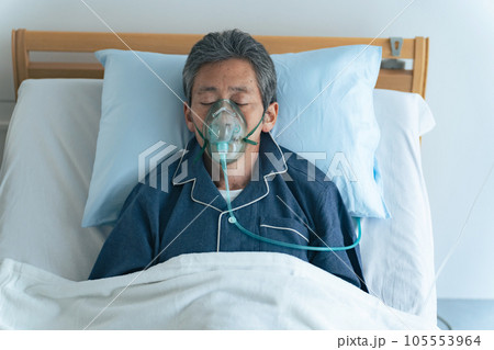 酸素マスクをつけてベッドに寝るシニア男性 酸素マスクをつけてベッドに寝るシニア男性 105553964
