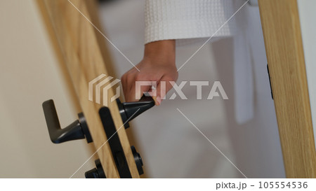 Woman hand in bathrobe opens or closes bathroom door 105554536