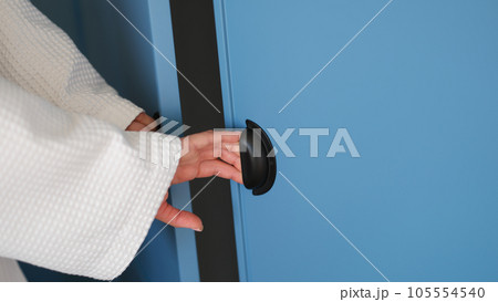 Female hands open doors of blue stylish closet at home Female hands open doors of blue stylish closet at home 105554540