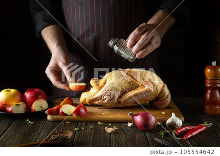 The cook adds salt to the raw duck before roasting. Cooking a national dish or Peking duck in the restaurant kitchen by the hands of the chef The cook adds salt to the raw duck before roasting. Cooking a national dish or Peking duck in the restaurant kitchen by the hands of the chef 105554642