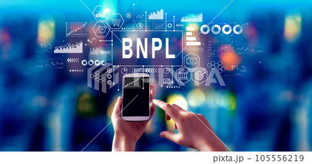 BNPL - Buy Now Pay Later theme with person using a smartphone at night 105556219