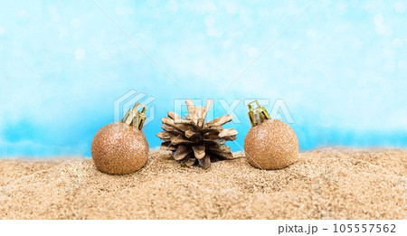 Shiny balls with pine cone on the beach. Concept for Christmas, New Year, Beach Party. Copy space Shiny balls with pine cone on the beach. Concept for Christmas, New Year, Beach Party. Copy space 105557562
