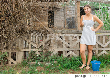 Young woman with bucket on farm. 105558317
