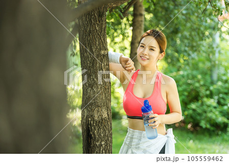a young woman wearing summer morning sportswear and carrying a water bottle 105559462