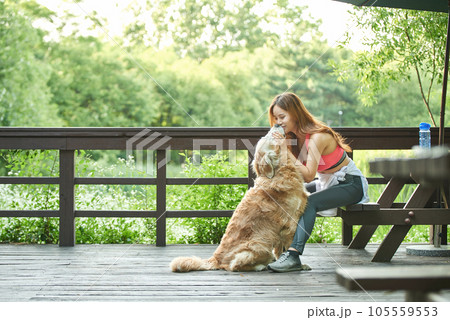 In the park, a lovely dog and a beautiful woman in sportswear are exercising together. 105559553