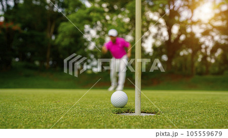 Golfer putting ball on the green golf, lens flare on sun set evening time. Golfer putting ball on the green golf, lens flare on sun set evening time. 105559679